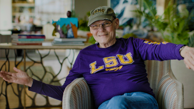 carville James Carville waiving hello wearing LSU sweatshirt. Movie Winning Is Everything Stupid